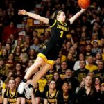 Molly Davis assistant coach standing courtside with Evansville Purple Aces during a game